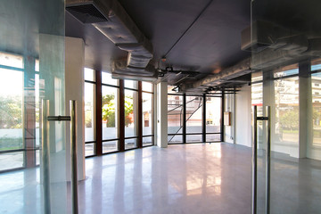 Bangkok,Thailand - October 19 , 2017 : Empty office room on modern building with sunlight and indoor ventilation system on hight ceiling of large building.
