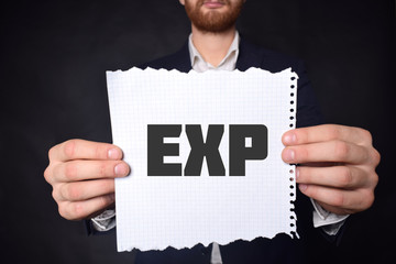 In the hands of a businessman a scrap of paper with the inscription:EXP