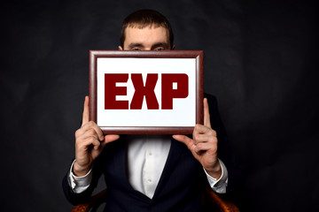 In the hands of a businessman a frame with the inscription:EXP