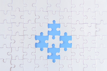 Jigsaw puzzle white on blue background.