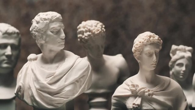 Panning between many famous roman sculptures busts made of marble. Closeup 