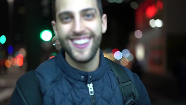 Portrait of young and funny guy with city night on background