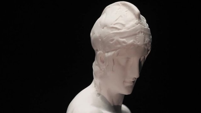 Ancient roman era white marble statue of Ares rotating and showing every angles. Closeup shot  with black background.