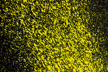 splashes of yellow aerosol paint on a black surface. background, texture