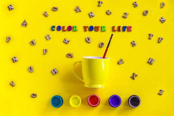 Lettering Color your life, jars gouache and yellow cup with paintbrush. Concept