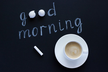 Text Good morning with chalk on black background cup coffee and