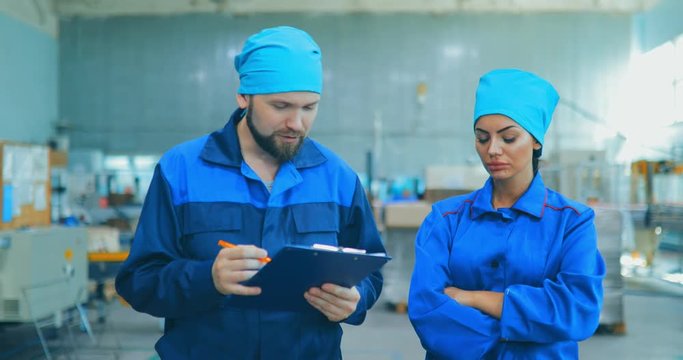 Workers at the factory of household chemicals, the production of liquid soap, going through the territory of an industrial enterprise and discussing something