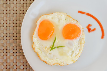 Traditional breakfast fried eggs on white dish - Top view