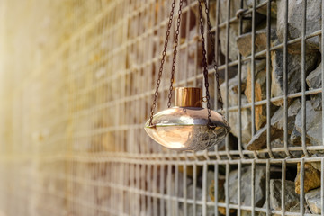 kerosene lamp hanging with gabion rock wall on background