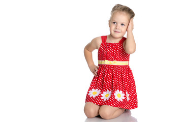 Little girl is sitting on the floor.