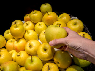 A female hand takes a Chinese pear with packing foam net in super market