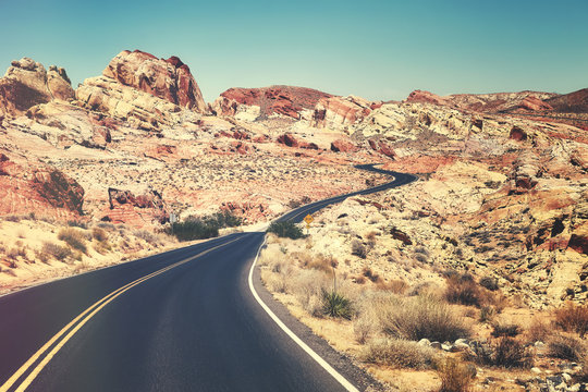 Retro toned picture of a scenic winding road, travel concept, Nevada, USA.