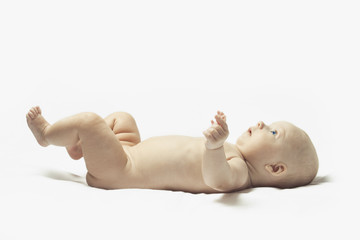 beautiful child without clothes lies on a white background