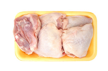 Raw chicken legs in a pack isolated on white background. Top view. Chicken thighs for cooking. 