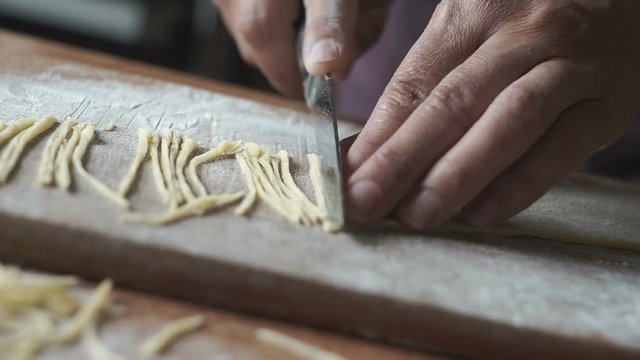 Woman hands of chef making egg homemade noodles