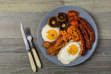 Full English breakfast, with sausage, mushrooms, beans and a fried egg.