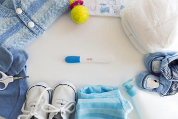 Different baby accessories with pregnancy test. Maternal concept. Baby things, sneakers, clothes, diapers, shoes © artursfoto