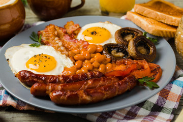 Full English breakfast, with sausage, mushrooms, beans and a fried egg.