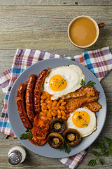Full English breakfast, with sausage, mushrooms, beans and a fried egg.