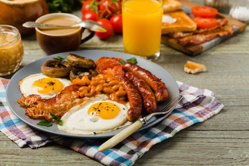Full English breakfast, with sausage, mushrooms, beans and a fried egg.