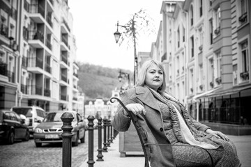 Obraz premium A woman of plus size, American or European appearance walks in the city enjoying life. A young lady with excess weight, xxl size at the center of the city. Natural beauty 