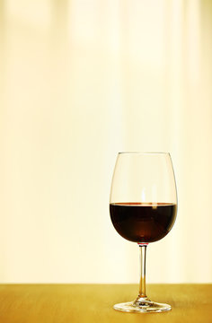 Single Red Wine in Bordeaux-shaped glass on Right Side of Copper Counter Top, with defocused Window and White Curtain, plain background, No decoration, Ambient Warm Day Lighting Studio image 2