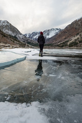 Standing on a frozen lake with snow capped peaks beyond