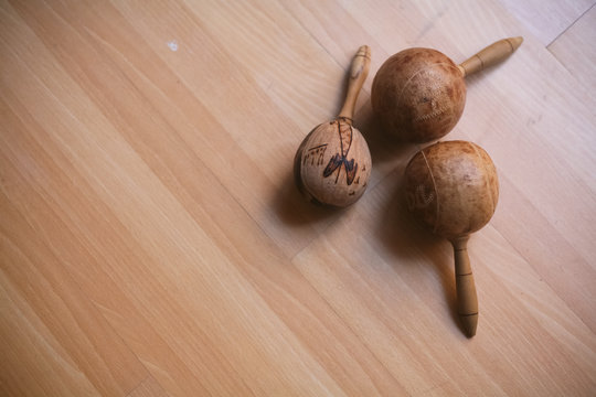 Maracas e instrumentos de percusi&oacute;n hechos con semillas sobre fondo de madera