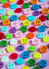 Fototapeta na wymiar buttons of different colors on a pink background. Pastel shades