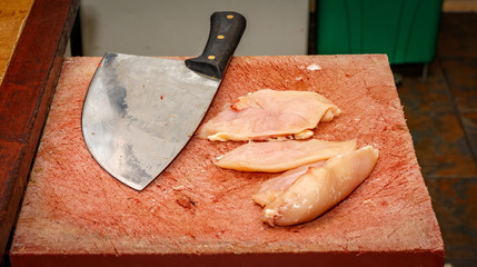 knife over wood with chicken breast
