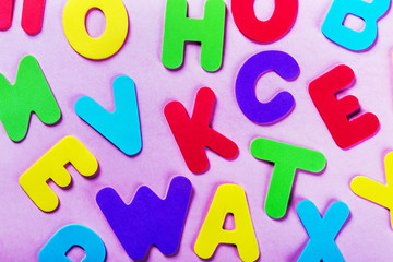 letters of the alphabet in different colors on a pink background