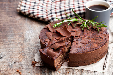 Baked  belgian chocolate cheesecake with chocolate ganache on wooden table