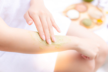 Obraz na płótnie Canvas Charming beautiful woman use herbal scrubs for scrubbing her old skin cells at her beautiful arm that makes better nice skin and skin rejuvenation. Gorgeous girl scrub skin by herself at home