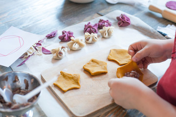 cooking class, culinary. food and people concept/ molding of pelmeni or meat dumplings, child hands...