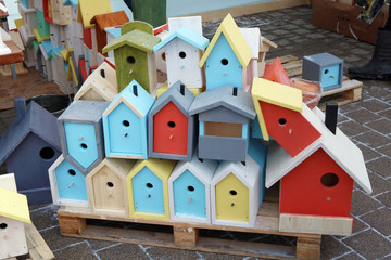 Obraz na płótnie Canvas Multicolored homemade birdhouses and feeders are sold on the street during the fair