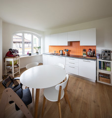 Kitchen with orange tiles and a modern table. Large window with a view