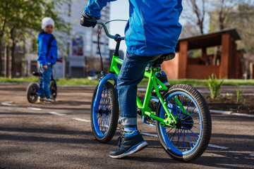 a child rides a children's green bike