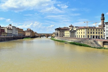 Fototapeta premium Muddy Arno river from Florence crossing the city of Florence, Italy. Picture was taken from Ponte alle Grazie in May.