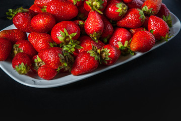 ripe red strawberries on a black background