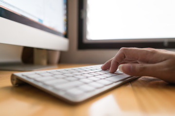 Close up hand business woman working office with computer keyboard. woman writing a blog. Female hands typing on keyboard with wood desk table