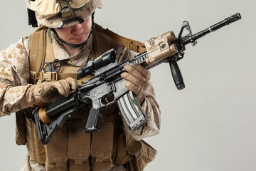 Fototapeta premium Soldier in camouflage holding rifle