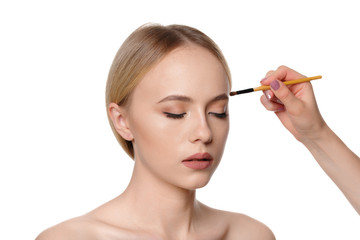 Beauty portrait of a smiling beautiful half naked woman posing with make-up brushes