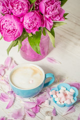 Fototapeta na wymiar Coffee with milk and flowers pink peonies. The atmosphere of relaxation.