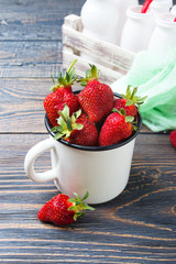 Fresh ripe strawberries in a rustic mug on a wooden table. Freshly harvested crop.