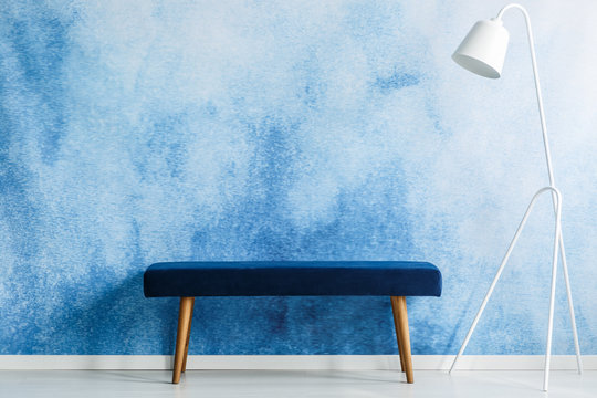 Blue bench and white lamp set on aquarelle wall in a waiting room interior. Place your product
