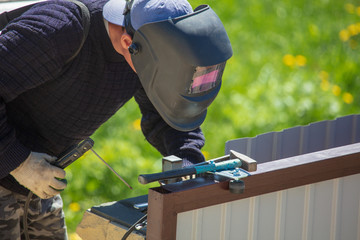 Welder welds metal at the construction site