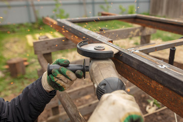 Worker cuts metal for doors at a construction site