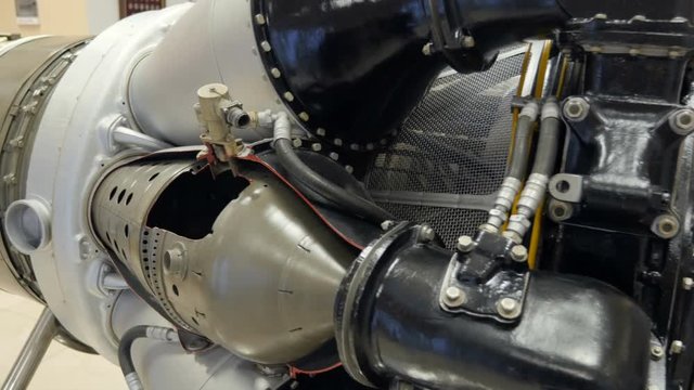 Panoramic view of parts of the turbine aircraft engine. Lots of pipes, pumps, compressors, gears, pulleys, blades, valves, hydraulic and servo drives and other elements.
