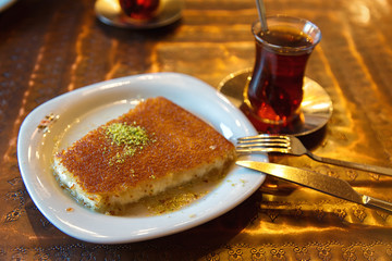 Turkish dessert kunefe with pistachio powder and tea