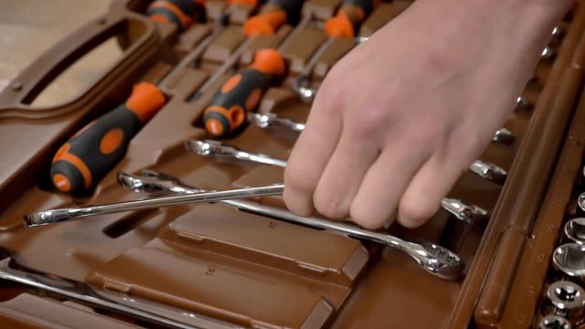 Girl is pointing to spanner in toolbox and taking it, repairing conception